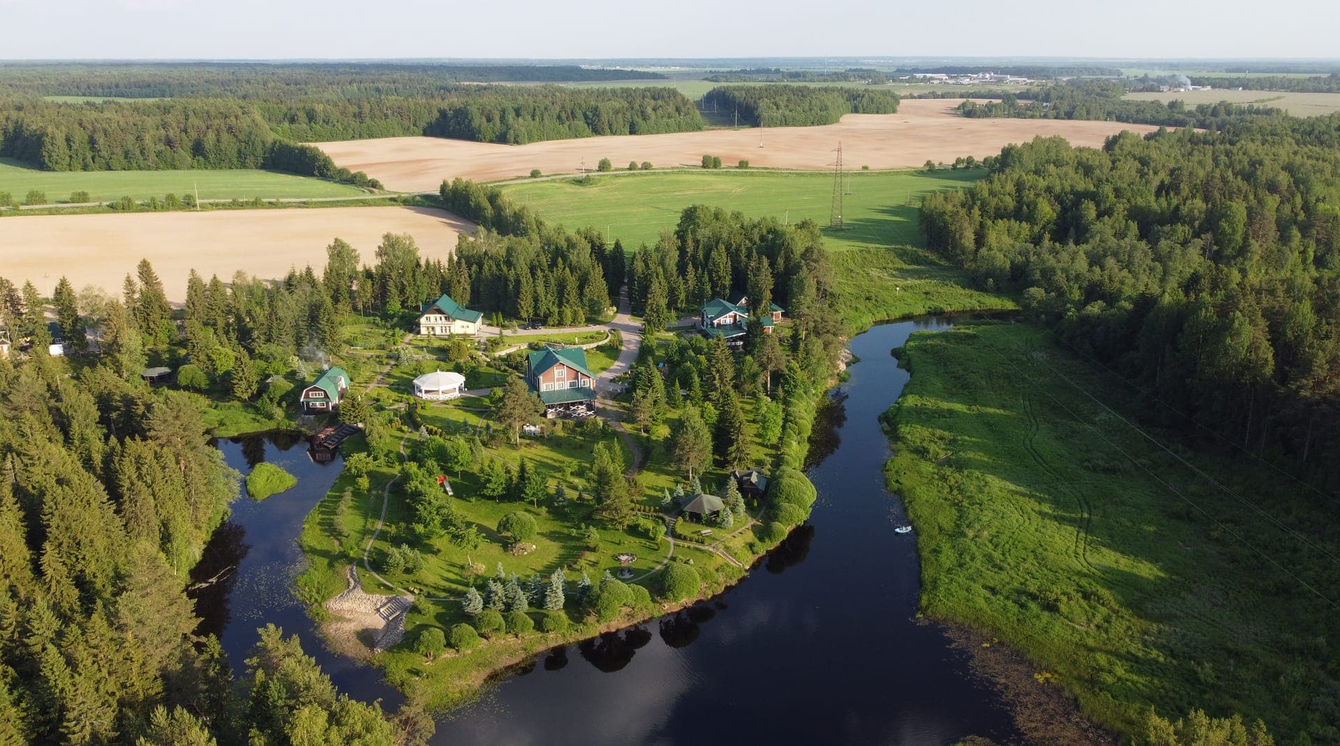 Aerial view of a river bend through forest and farmland
